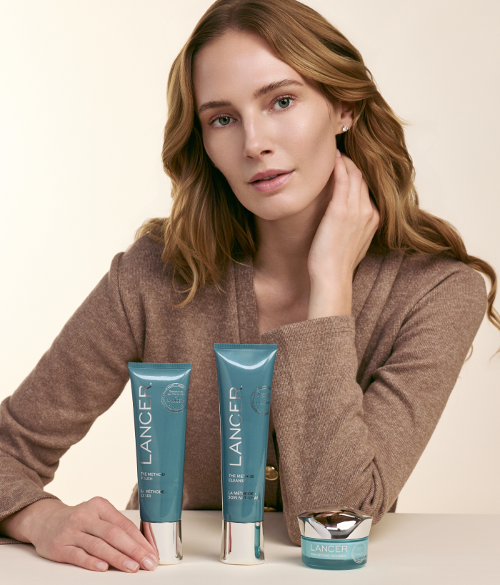 Woman with Lancer skincare products on a beige background-Lancer Skincare