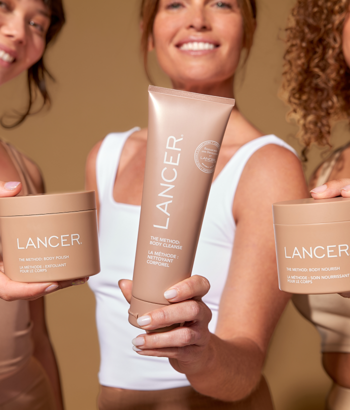Three people holding Lancer skincare products against a neutral background-Lancer Skincare