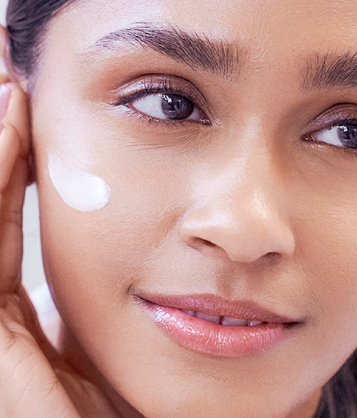Close-up of a woman applying cream to her face-Lancer Skincare