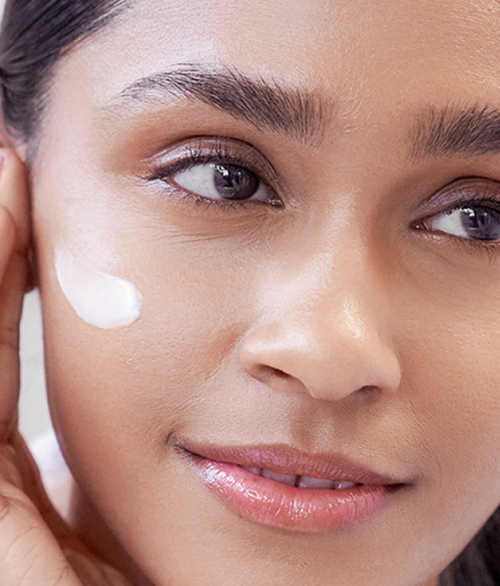 Close-up of a woman's face with a skincare product applied to her cheek.-Lancer Skincare