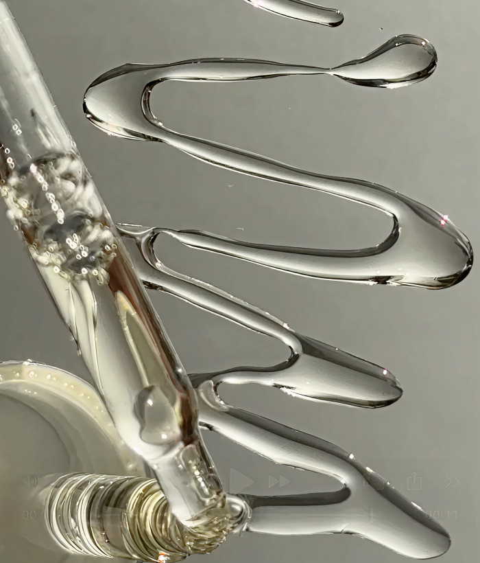 Close-up of a dropper with omega face oil being dispensed onto a reflective surface.-Lancer Skincare