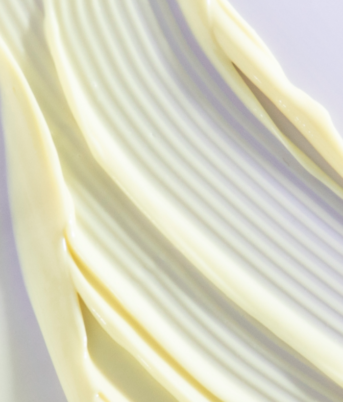 Close-up of smooth, light-colored cream on a white background