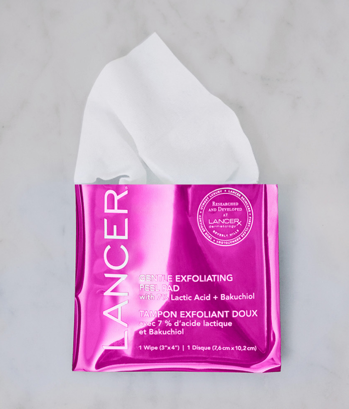 Pink Lancer exfoliating pad packaging with a white peel pad wipe on a gray background-Lancer Skincare